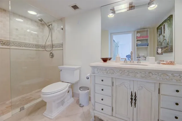 a bathroom with a granite countertop sink mirror vanity and toilet