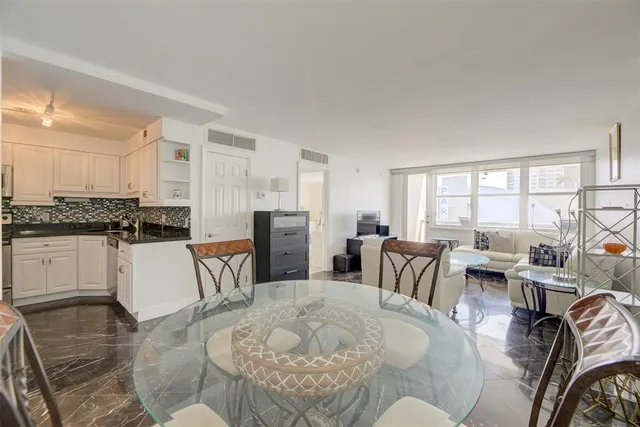 a kitchen with a dining table chairs and white appliances