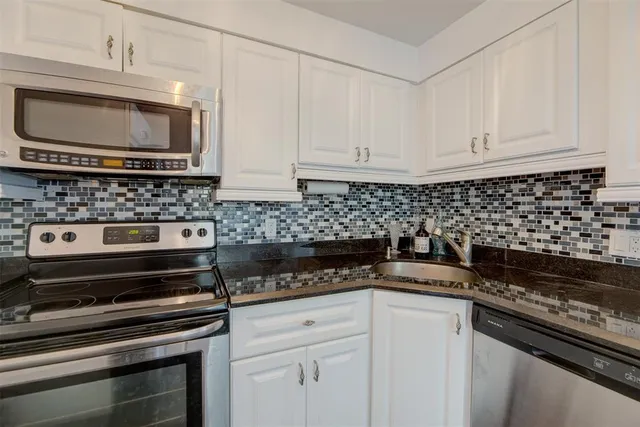 a kitchen with granite countertop a stove and a microwave