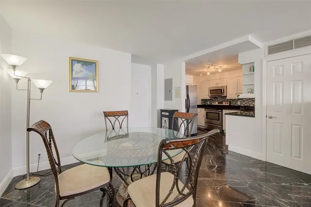 a view of a dining room with furniture and a kitchen