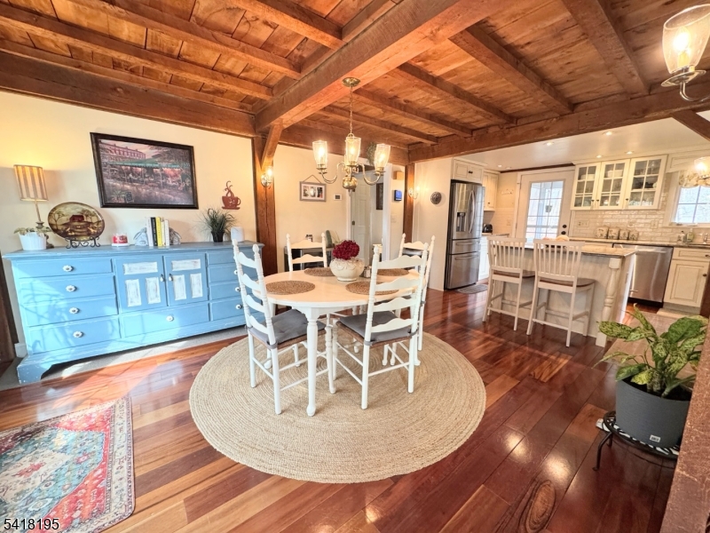 60 Plotts Road Newton, NJ 07860 - Photo 12 of 36 a dining room with wooden floor a chandelier a wooden table and chairs