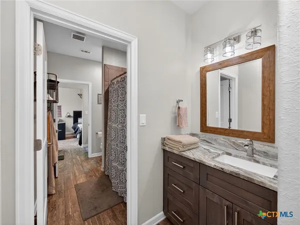 a view of a hallway with wooden floor and entryway