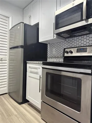 a kitchen with granite countertop cabinets and steel stainless steel appliances