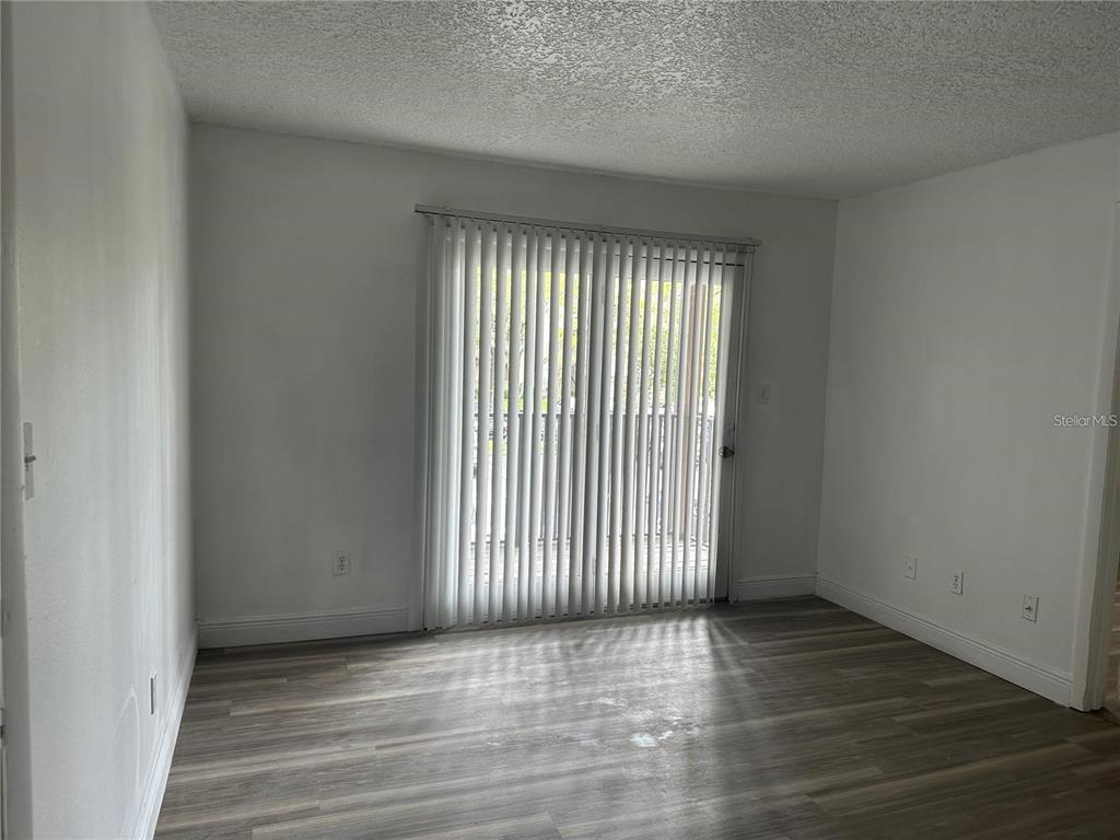 241 Afton Square, Unit 205 Altamonte Springs, FL 32714 - Photo 6 of 32 an empty room with wooden floor and windows