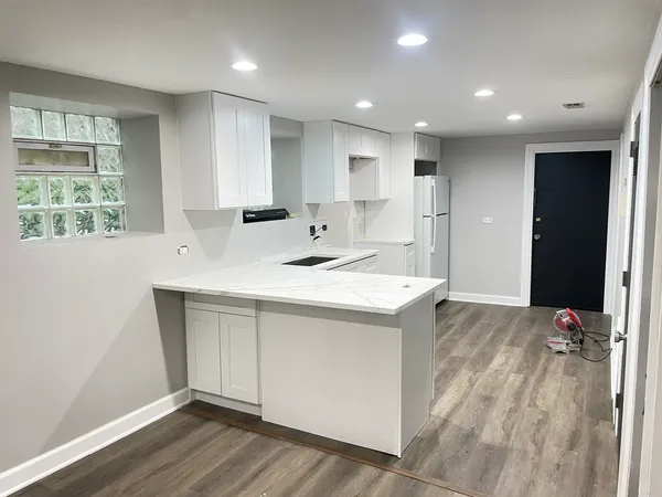 a kitchen with kitchen island a sink stainless steel appliances and window