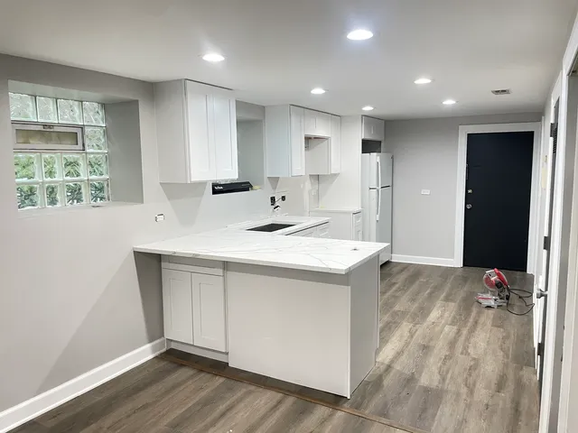 a kitchen with kitchen island a sink stainless steel appliances and window