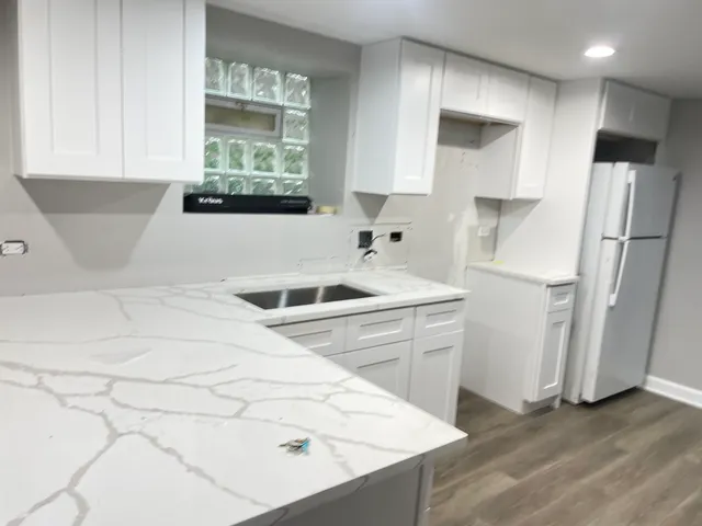a kitchen with a refrigerator sink and cabinets
