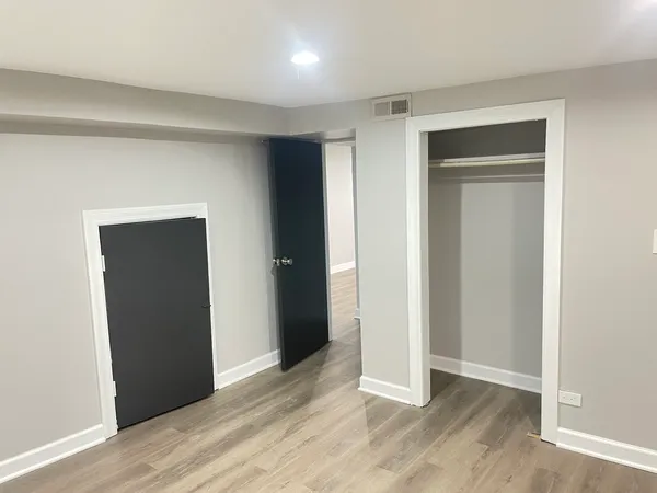 an empty room with wooden floor & closet