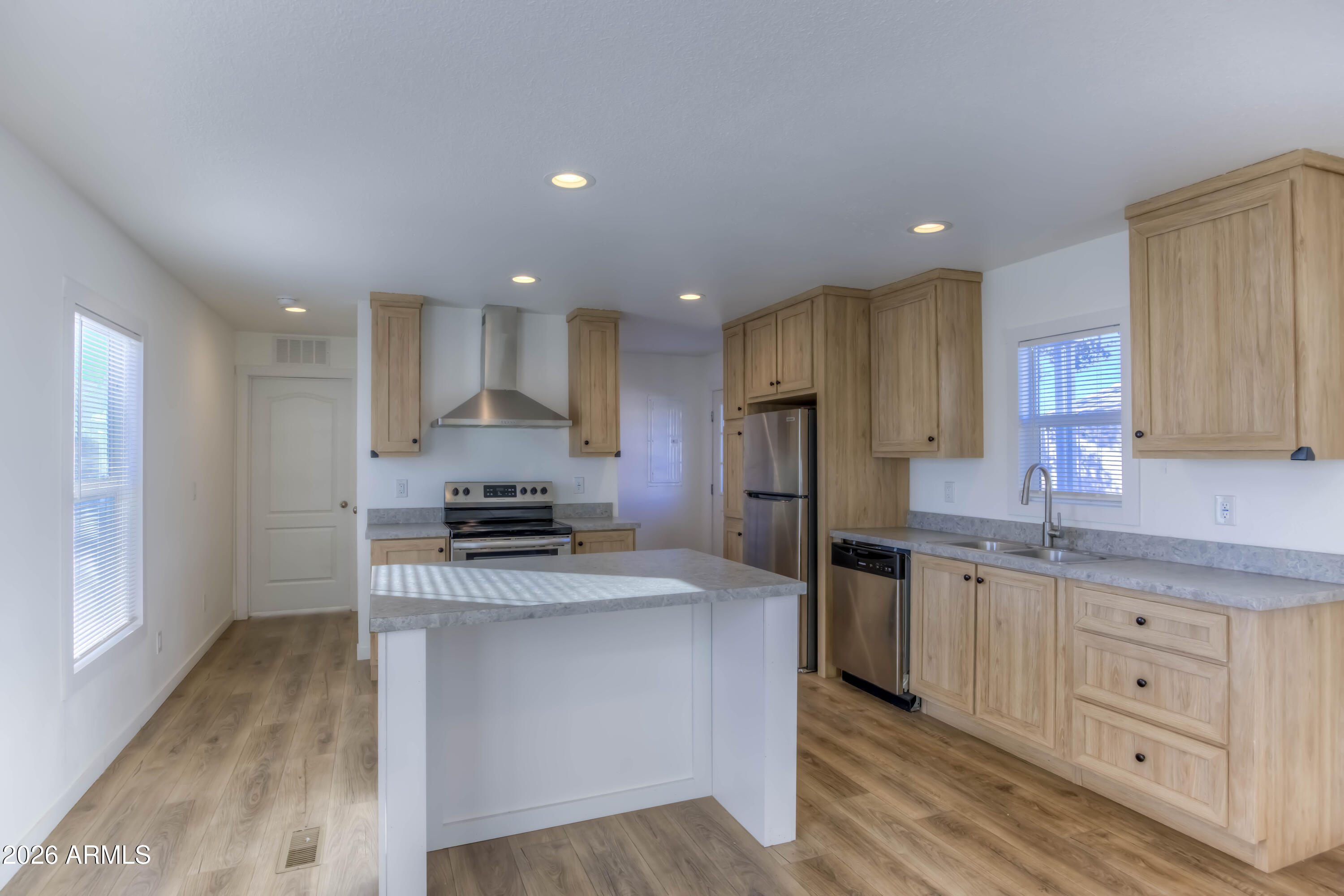 a kitchen with stainless steel appliances granite countertop a stove a sink and a refrigerator