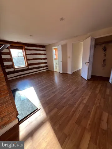 a view of empty room with wooden floor and window