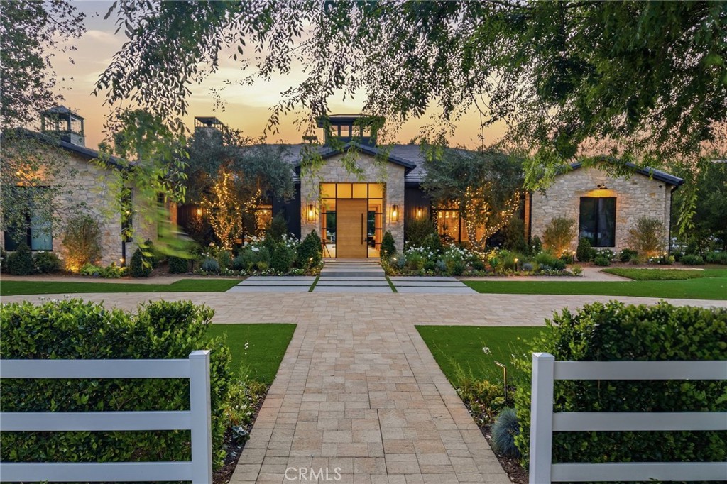 5241 Twin Oaks Road Hidden Hills, CA 91302 - Photo 1 of 69 a front view of a house with a yard and potted plants