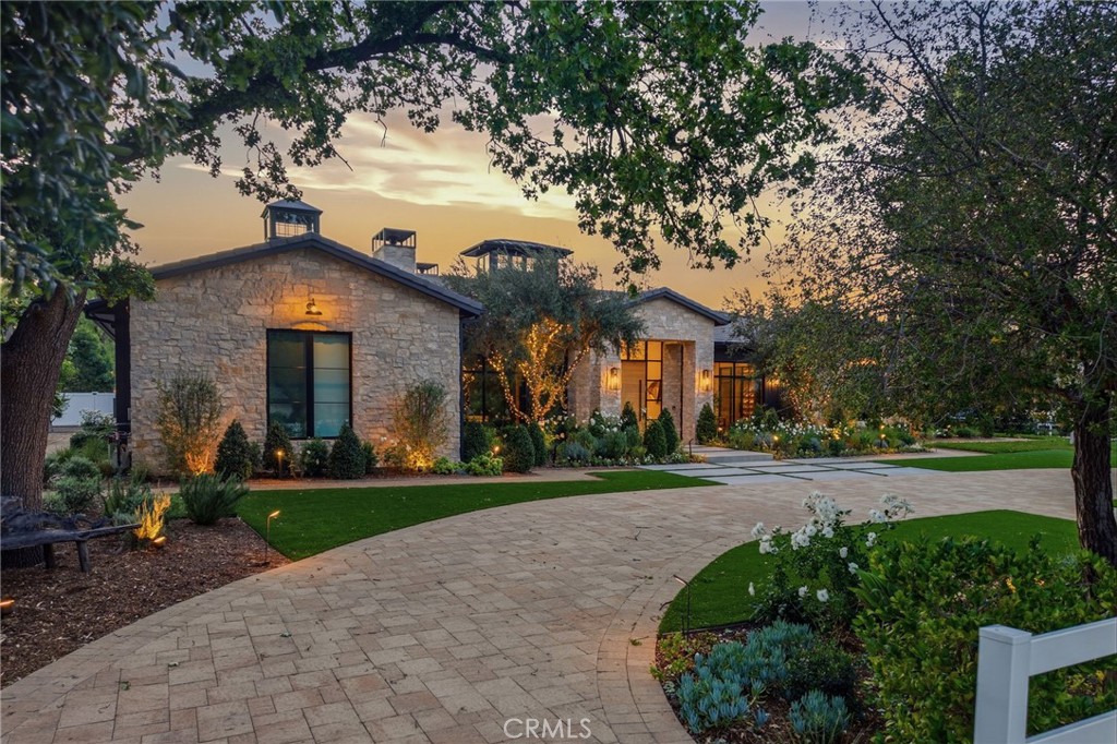 5241 Twin Oaks Road Hidden Hills, CA 91302 - Photo 2 of 69 a front view of a house with a yard and potted plants