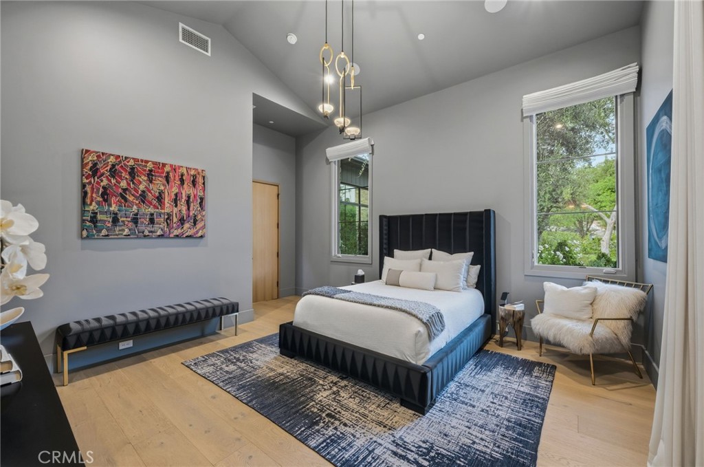 5241 Twin Oaks Road Hidden Hills, CA 91302 - Photo 48 of 69 a spacious bedroom with a large bed chandelier and a window
