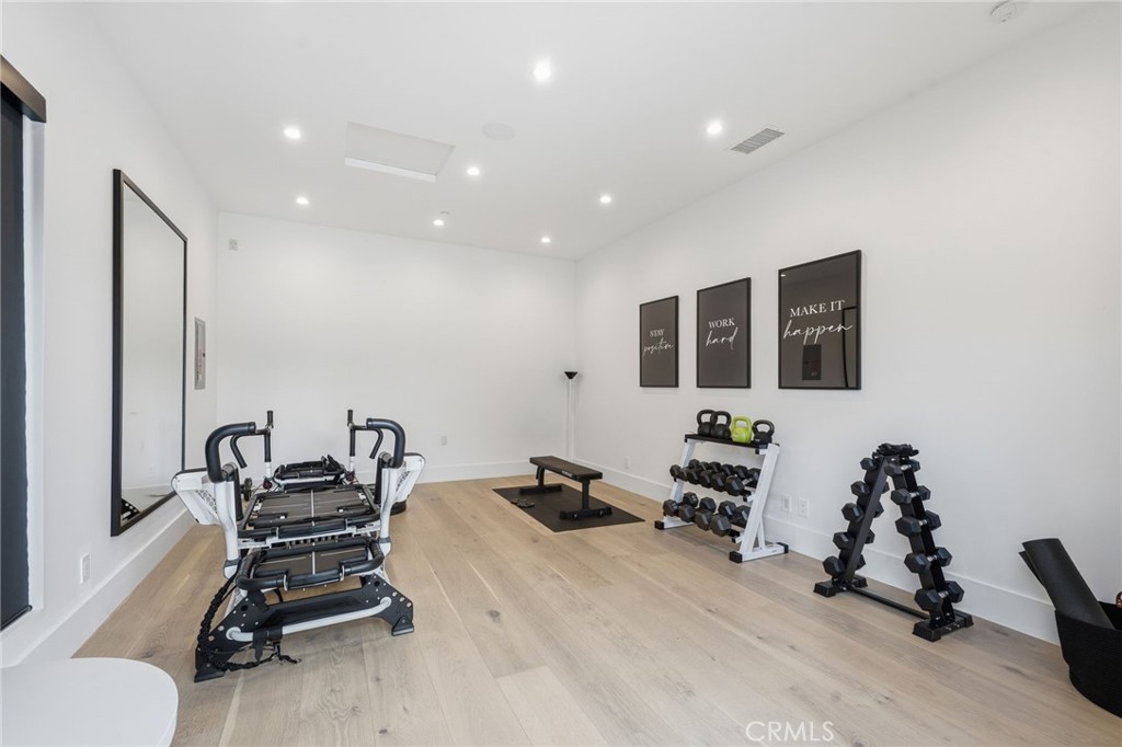 5241 Twin Oaks Road Hidden Hills, CA 91302 - Photo 56 of 69 a room with gym equipment and a flat screen tv