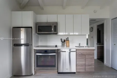 a kitchen with cabinets stainless steel appliances and sink