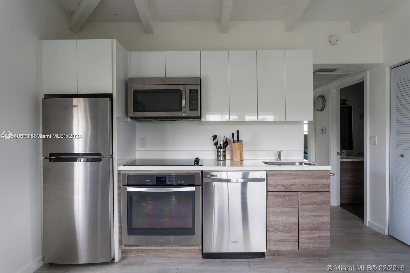 1450 Meridian Avenue, Unit 201 Miami Beach, FL 33139 - Photo 7 of 19 a kitchen with cabinets stainless steel appliances and sink