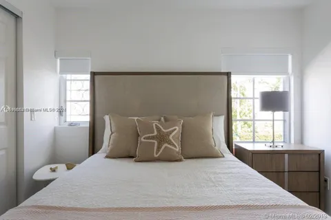 a large bed sitting in a bedroom next to a window