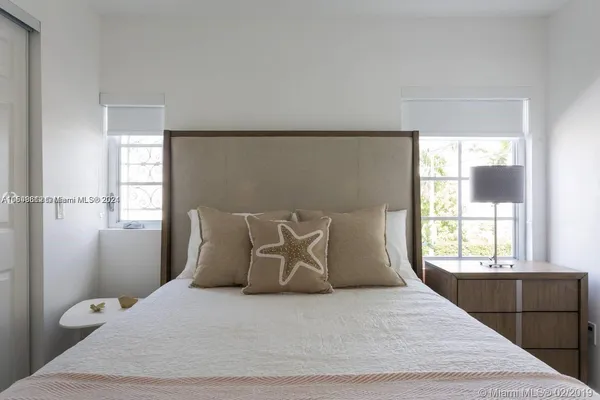 a large bed sitting in a bedroom next to a window