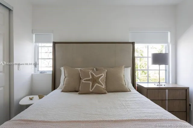 a large bed sitting in a bedroom next to a window