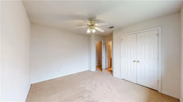 a view of a big room with chandelier fan