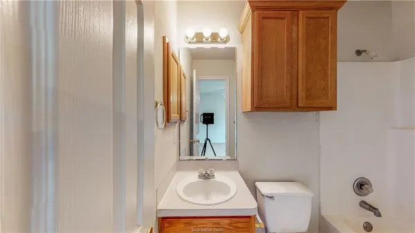 a bathroom with a toilet a sink and mirror