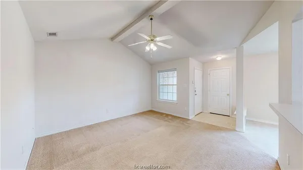 an empty room with chandelier fan and windows