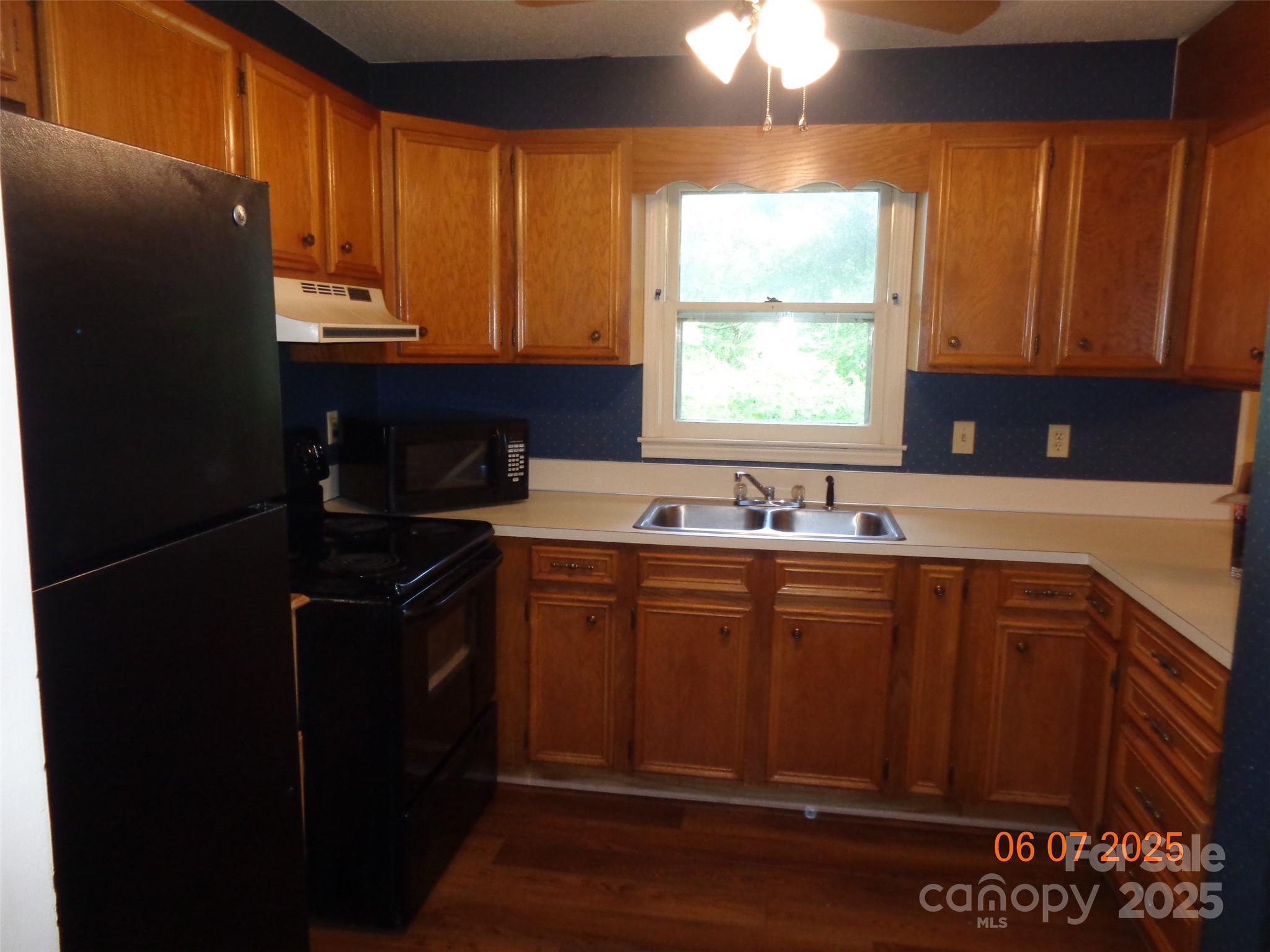 1203 Dudley Shoals Road Granite Falls, NC 28630 - Photo 11 of 32 a kitchen with a sink a window and cabinets