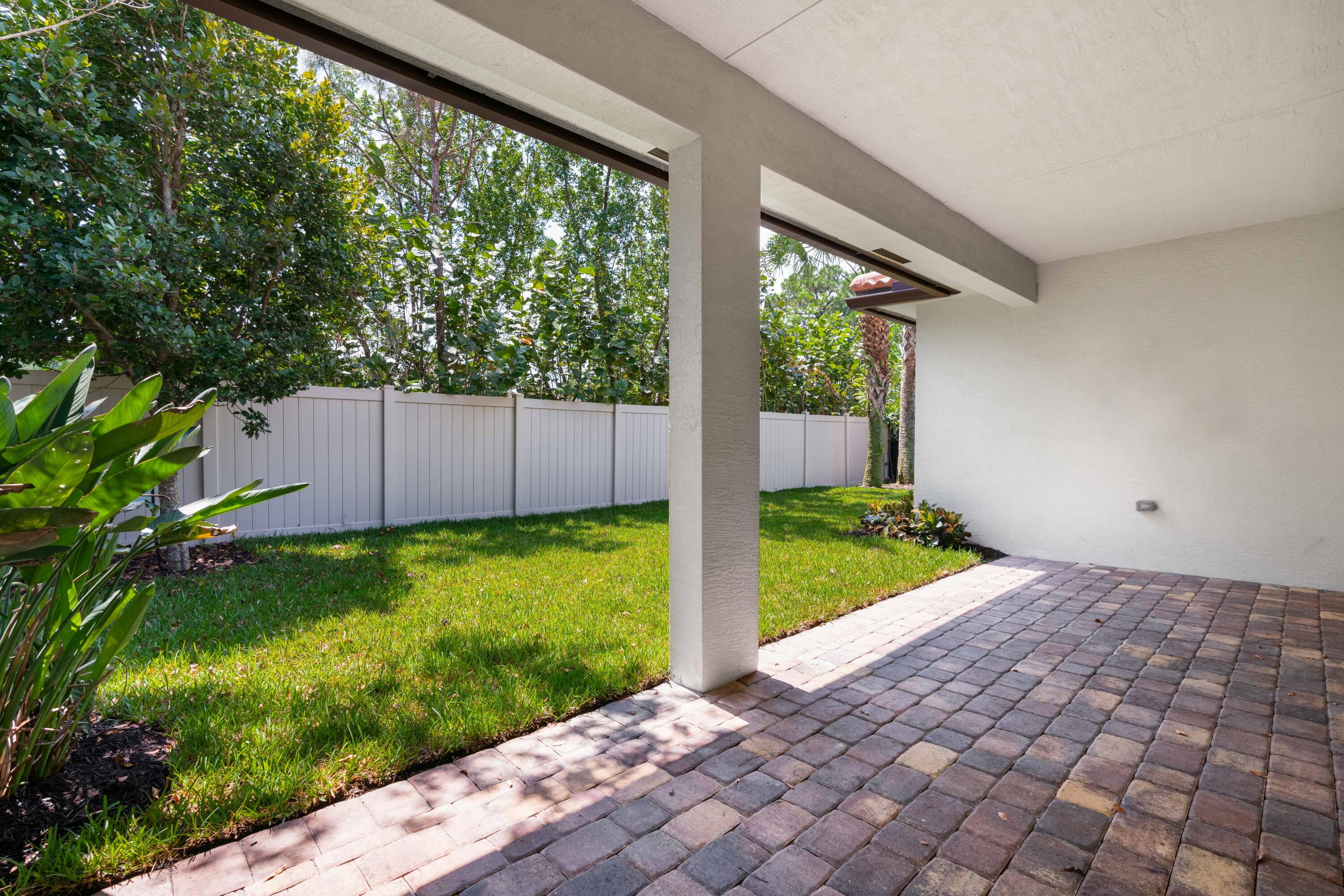 7018 Limestone Cay Road Jupiter, FL 33458 - Photo 17 of 23 a view of backyard with potted plants and a bench