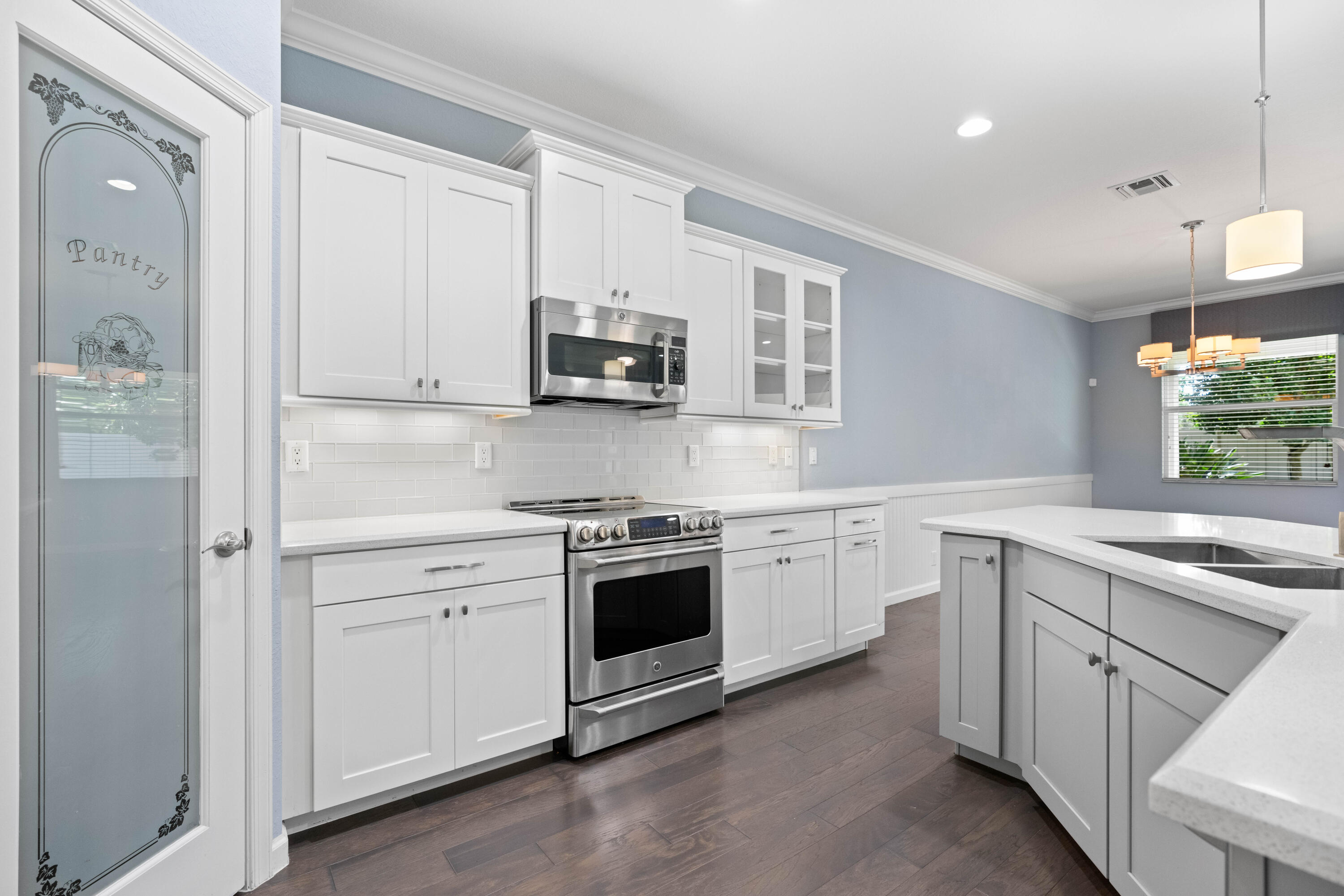7018 Limestone Cay Road Jupiter, FL 33458 - Photo 3 of 23 a kitchen with stainless steel appliances granite countertop white cabinets a sink a stove a window and a refrigerator