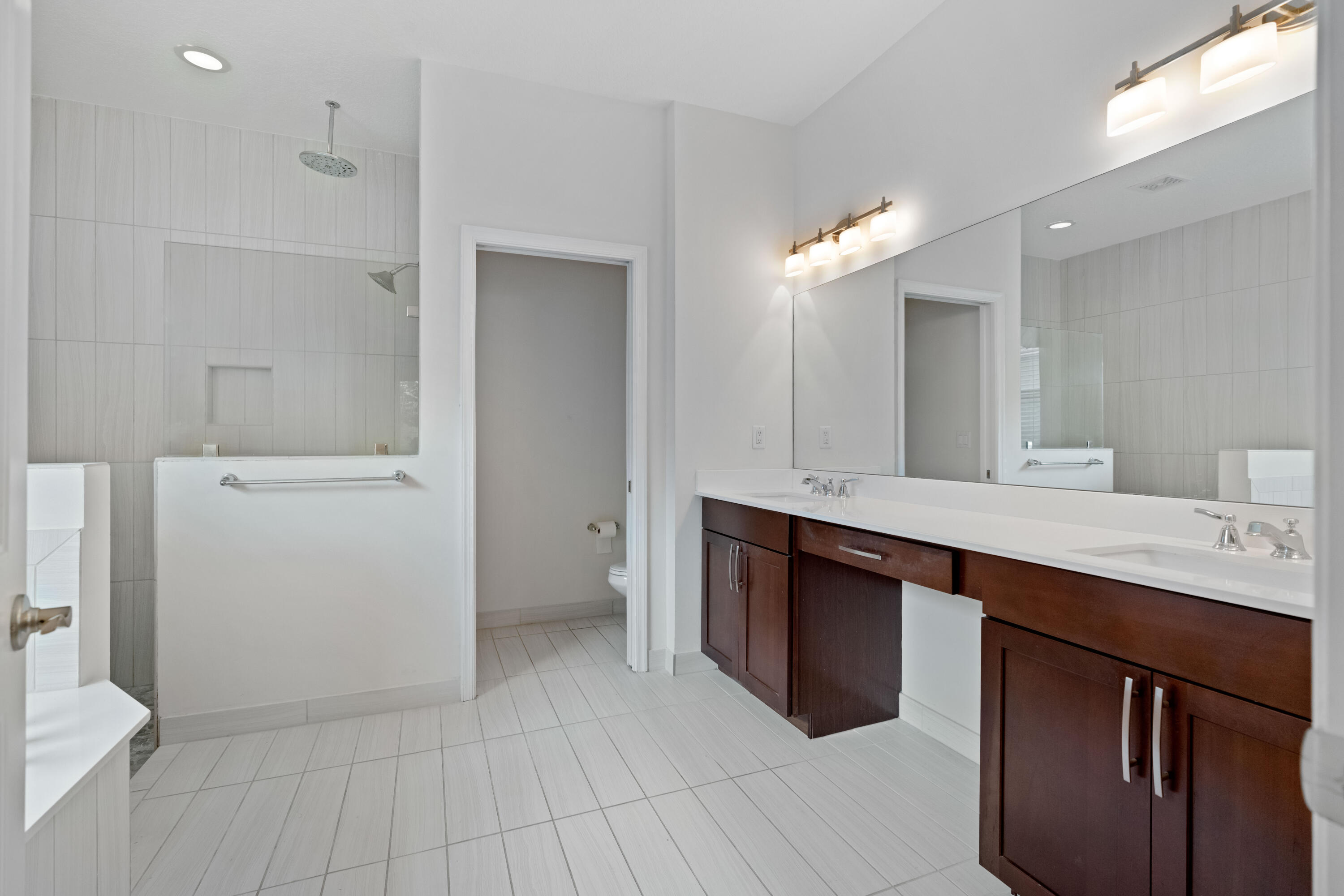 7018 Limestone Cay Road Jupiter, FL 33458 - Photo 6 of 23 a bathroom with a double vanity sink a toilet and a mirror