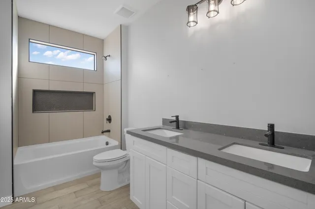a bathroom with a granite countertop sink a toilet and bathtub