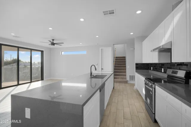 a kitchen with stainless steel appliances granite countertop a sink and stove