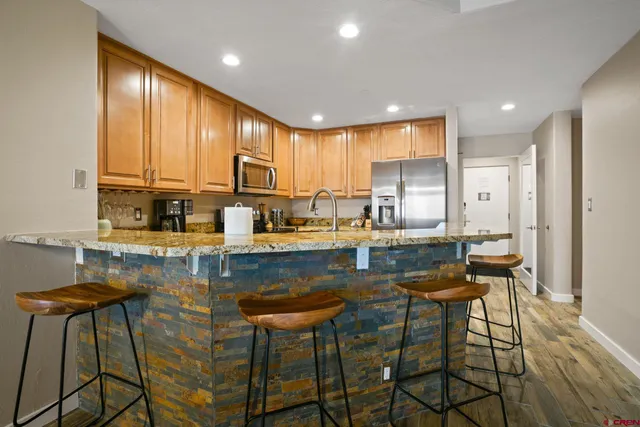 a kitchen with kitchen island granite countertop wooden cabinets and counter space