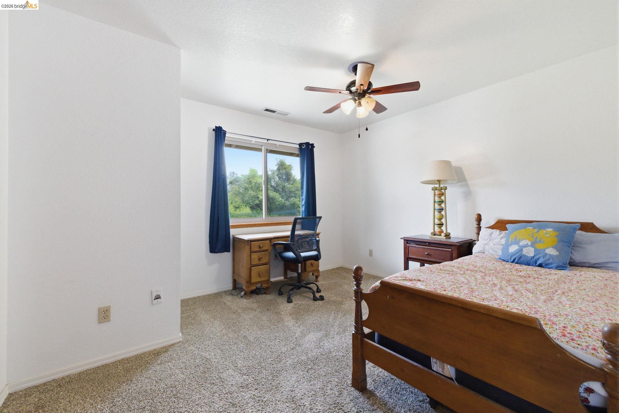 16860 Buckhorn Mountain Road Sonora, CA 95370 - Photo 15 of 46 Carpeted bedroom featuring a desk and a ceiling fan