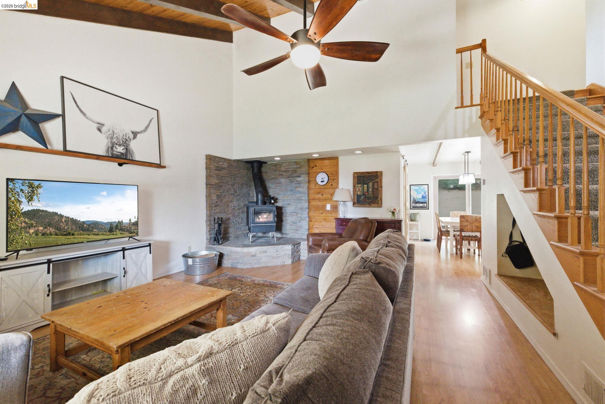 16860 Buckhorn Mountain Road Sonora, CA 95370 - Photo 24 of 46 Living area with a wood stove, a ceiling fan, and wood finished floors