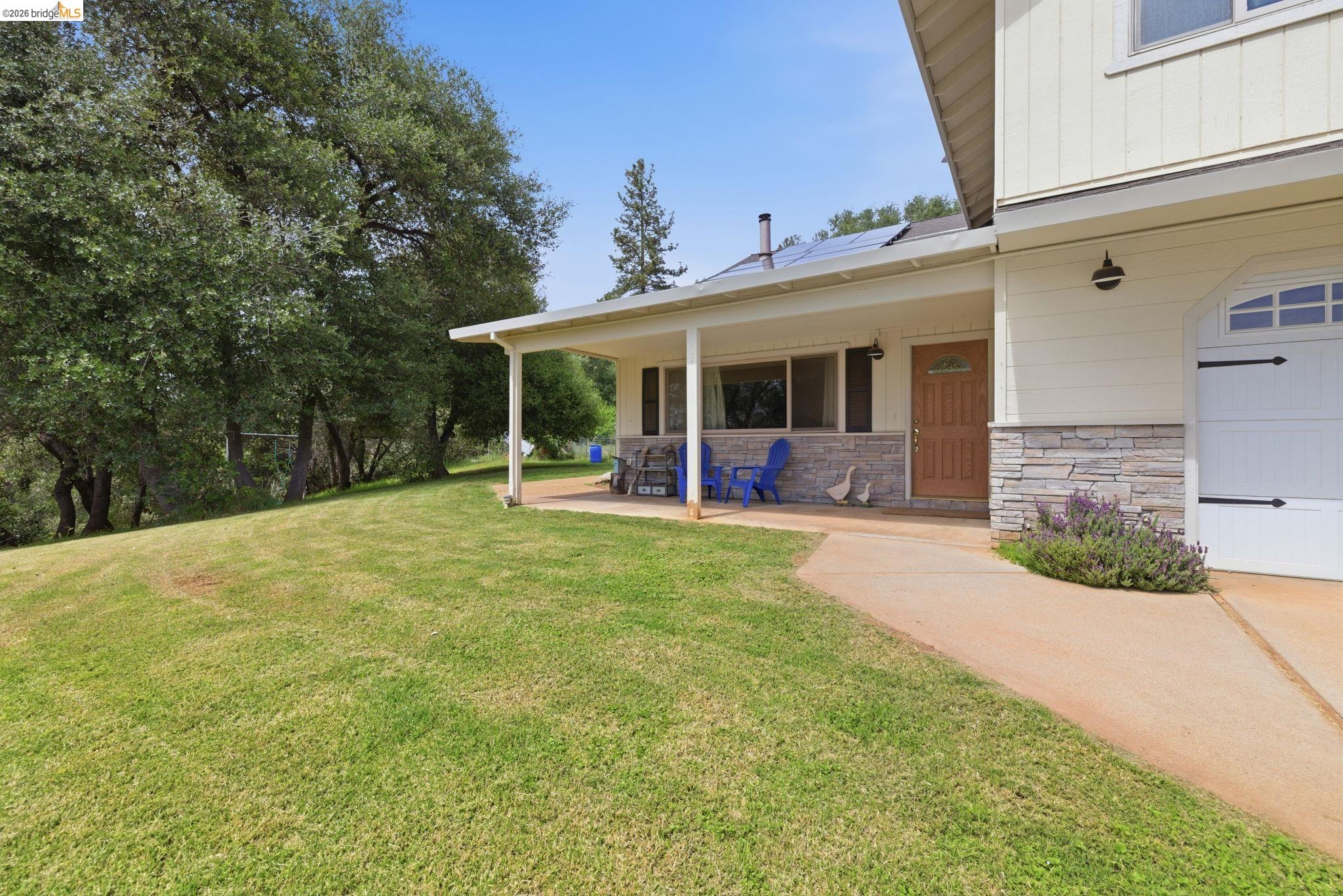 16860 Buckhorn Mountain Road Sonora, CA 95370 - Photo 3 of 46 View of green lawn with covered porch