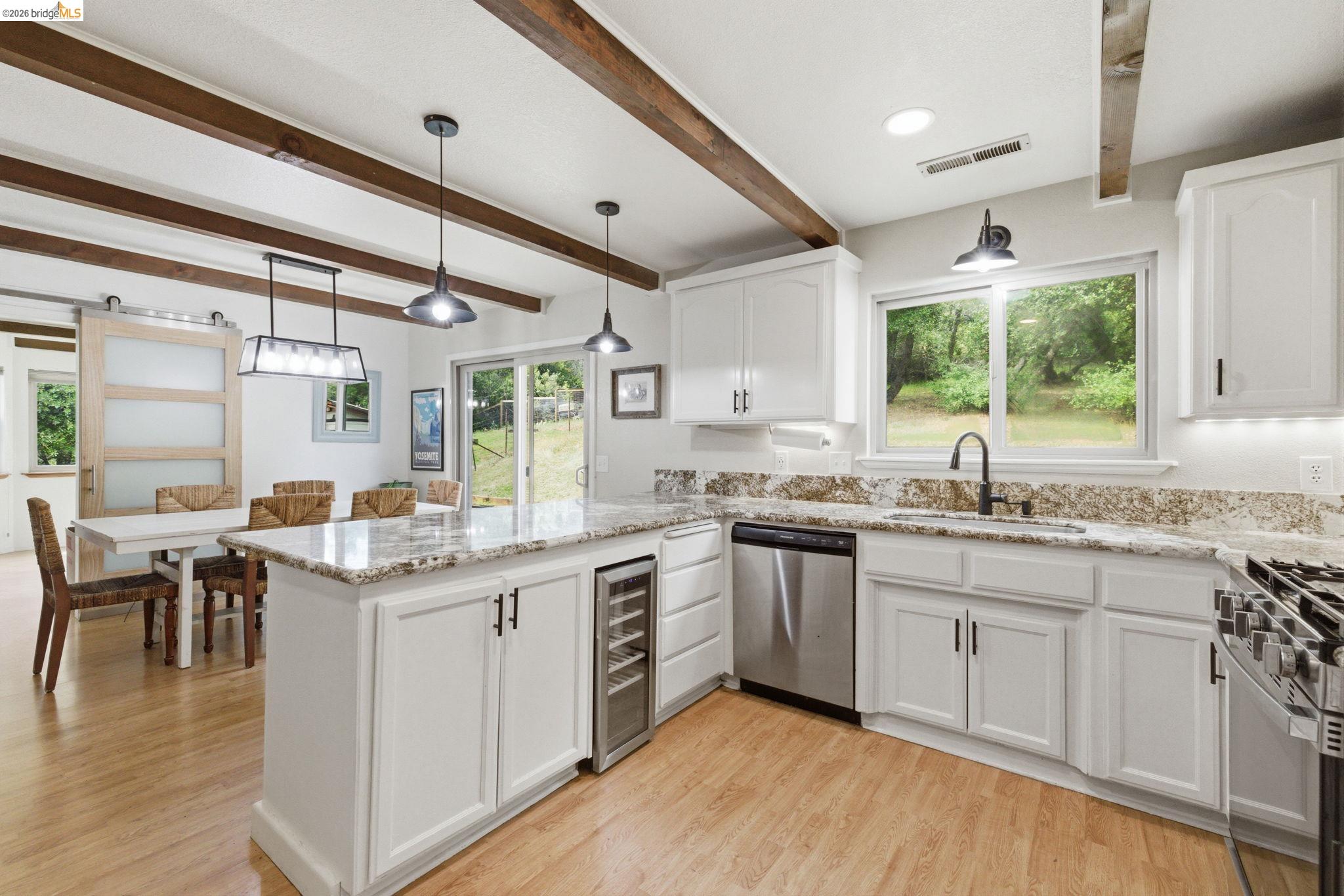16860 Buckhorn Mountain Road Sonora, CA 95370 - Photo 31 of 46 Kitchen with white cabinets, light wood-style flooring, light stone counters, a peninsula, and stainless steel appliances