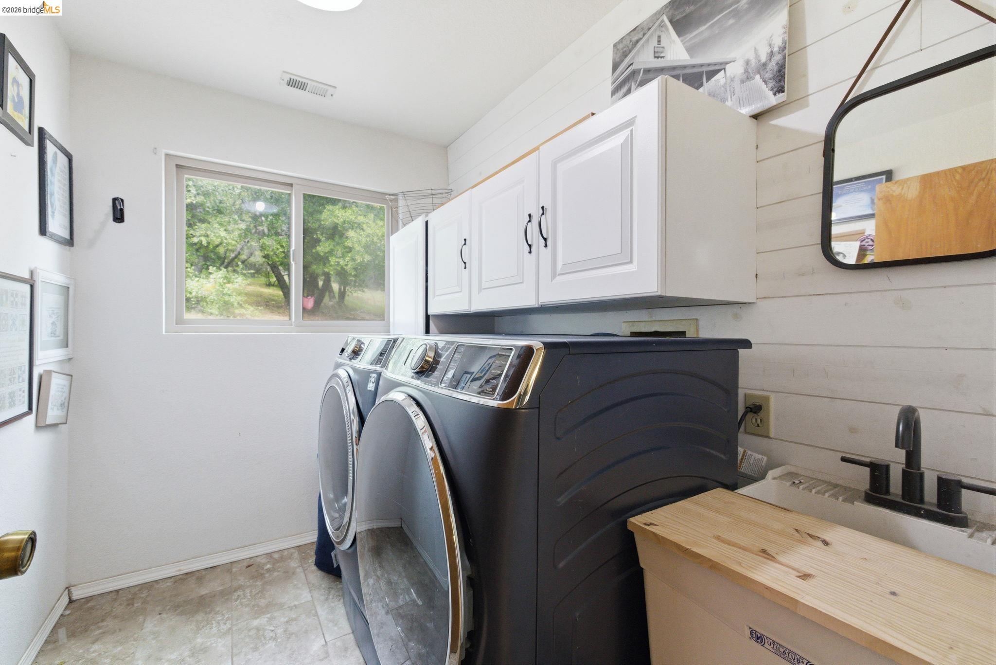 16860 Buckhorn Mountain Road Sonora, CA 95370 - Photo 35 of 46 Laundry area featuring cabinet space, washing machine and dryer, and wooden walls