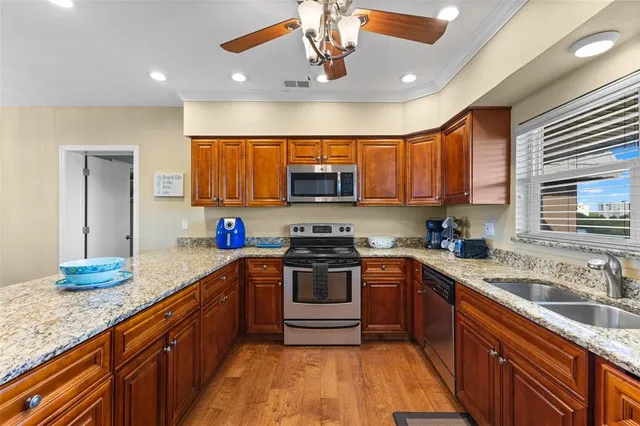 a kitchen with stainless steel appliances granite countertop a sink stove and refrigerator