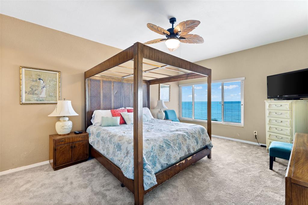 60 Gulf Boulevard, Unit 402 Indian Rocks Beach, FL 33785 - Photo 18 of 31 a bedroom with a bed a window and a flat screen tv