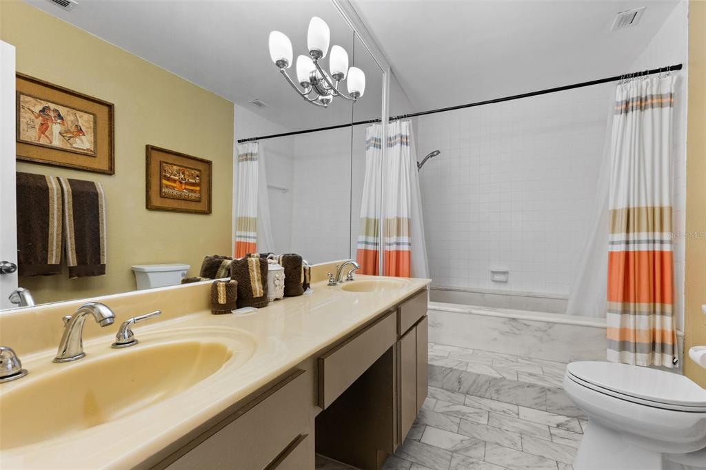 60 Gulf Boulevard, Unit 402 Indian Rocks Beach, FL 33785 - Photo 19 of 31 a bathroom with a double vanity sink and a mirror