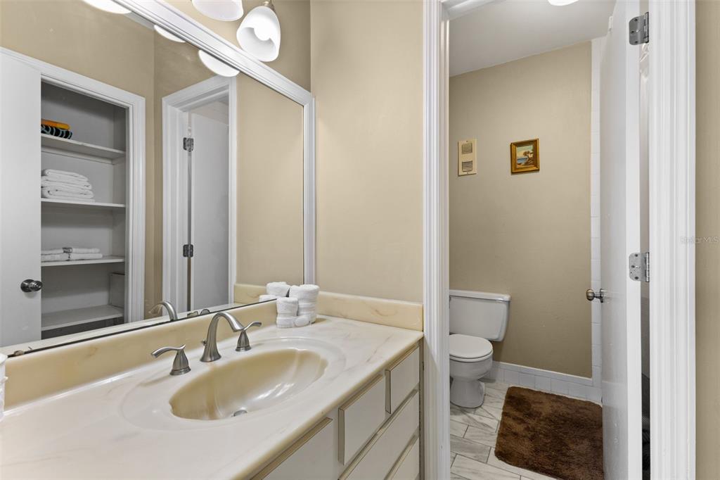 60 Gulf Boulevard, Unit 402 Indian Rocks Beach, FL 33785 - Photo 21 of 31 a bathroom with a granite countertop sink a toilet and a mirror