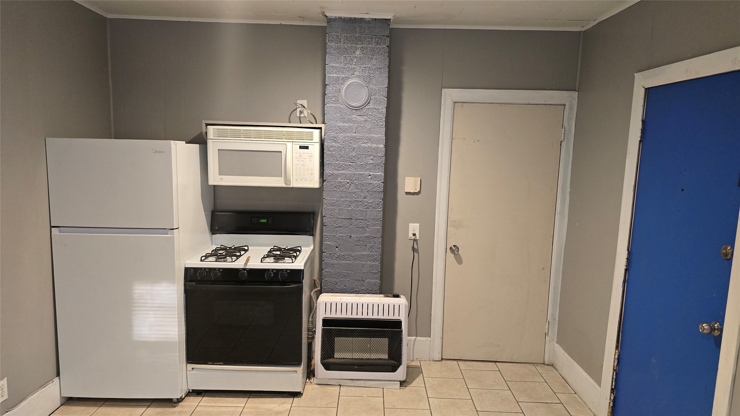 18327 Blake Manor Road, Unit A Manor, TX 78653 - Photo 4 of 21 Kitchen featuring white appliances, heating unit, light tile patterned floors, and ornamental molding