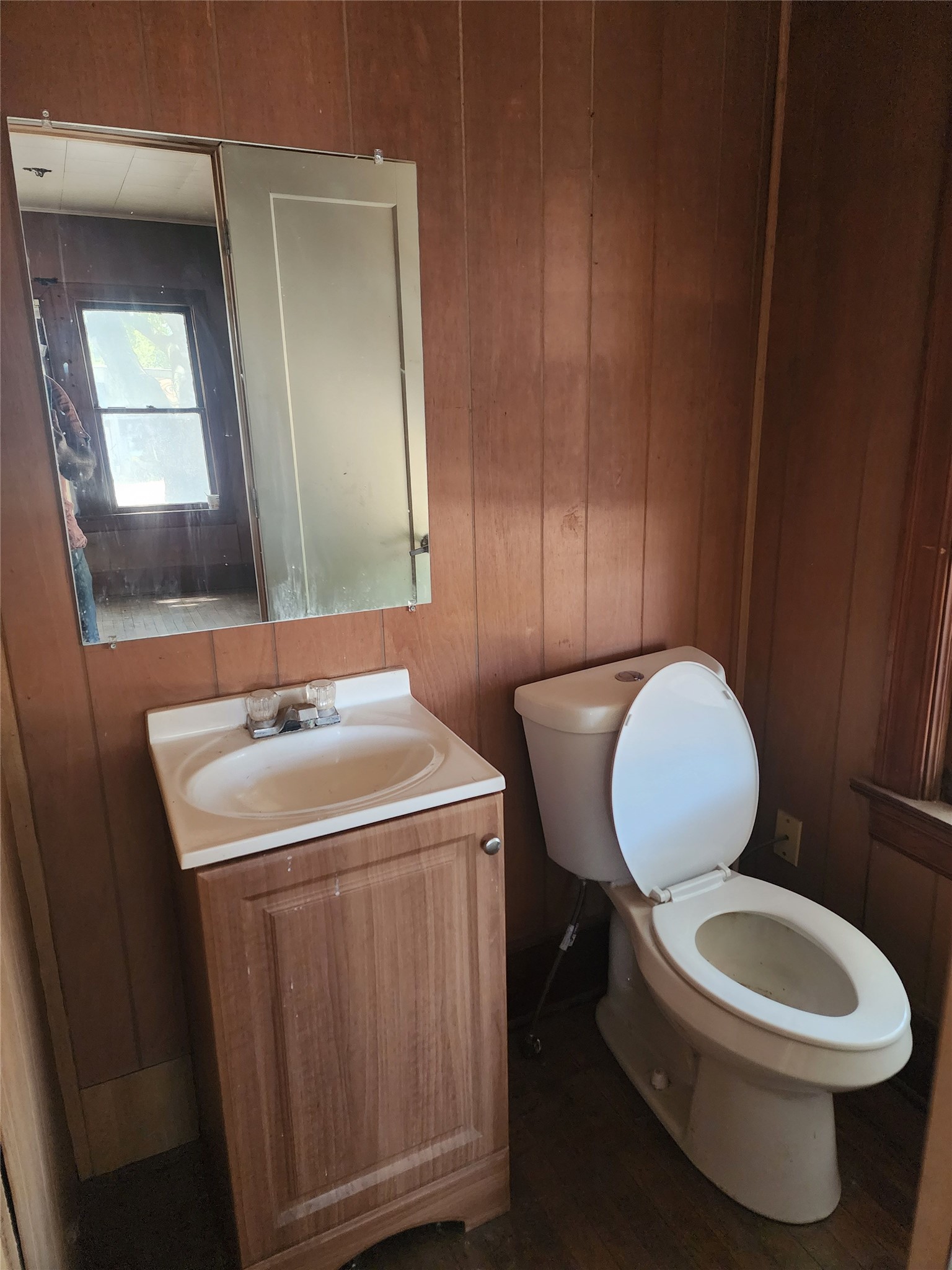18327 Blake Manor Road, Unit A Manor, TX 78653 - Photo 5 of 21 Half bath with vanity, wood walls, and dark wood finished floors