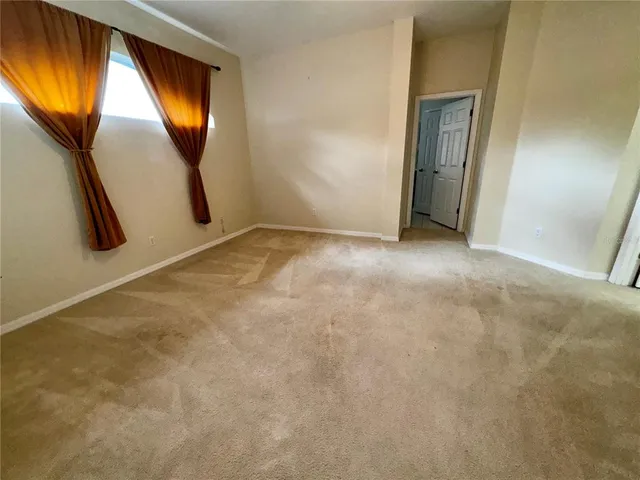 an empty room with a window and mirror