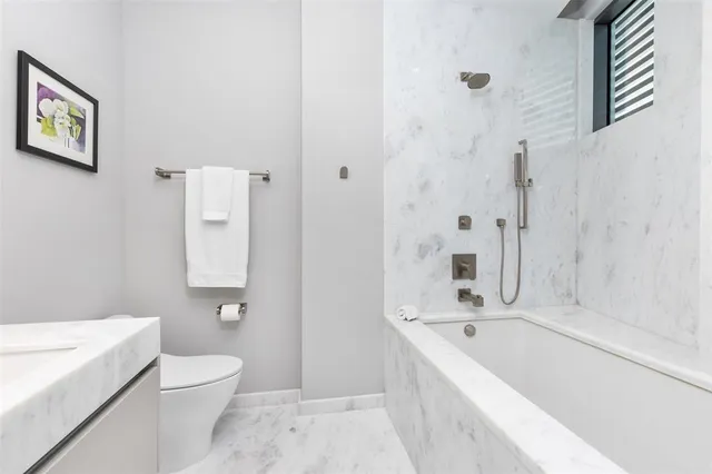 a view of a white house with a big yard and potted plants