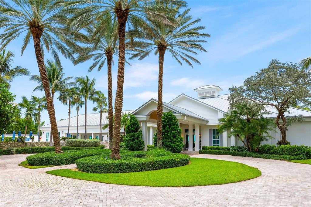 34 Minnetonka Road Sea Ranch Lakes, FL 33308 - Photo 82 of 89 a view of a white house with a big yard and potted plants