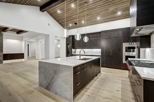 a large kitchen with stainless steel appliances granite countertop a sink and stove