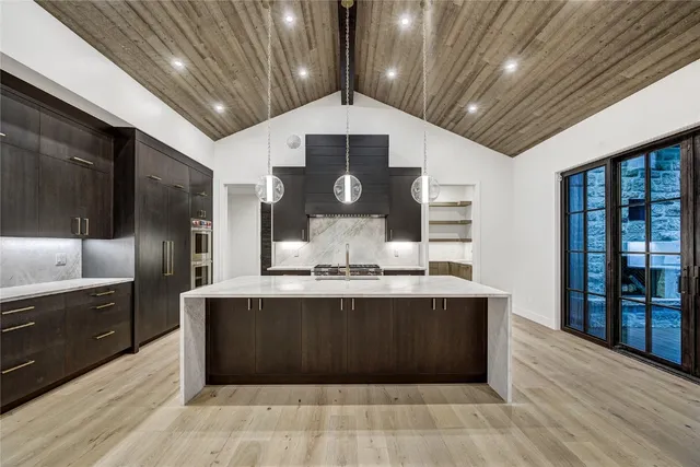 a large kitchen with stainless steel appliances granite countertop a large counter space a sink and cabinets