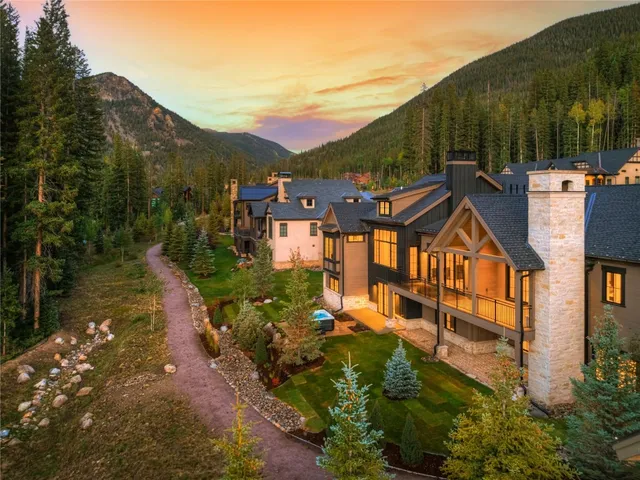 an aerial view of residential houses with outdoor space and trees